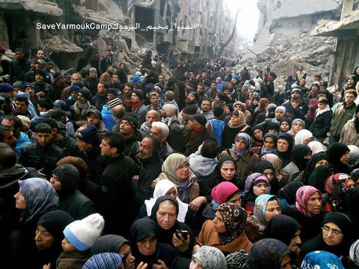 Mensen wachten op voedselpakketten in Yarmouk, 30 januari 2014